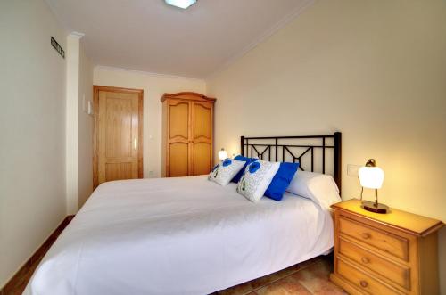 a bedroom with a large white bed with blue pillows at El Val in Arguedas