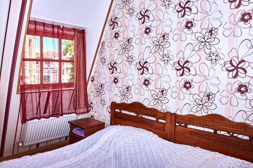 1 dormitorio con 1 cama y papel pintado con motivos florales en California Guest House, en Gori