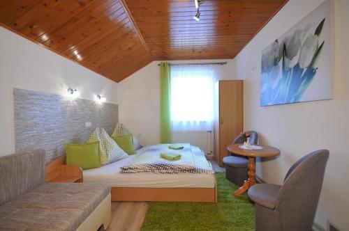 a bedroom with a bed and a table and a window at Penzión pod Troma Korunami in Červený Kláštor