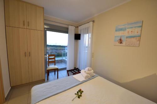 sypialnia z łóżkiem i balkonem w obiekcie Edem Suites w mieście Marathópolis