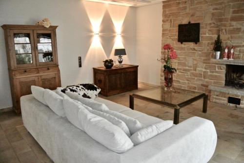 a living room with a white couch and a fireplace at Haus Kranenborgh im Mühlenspiegel Steinhude am Meer in Steinhude