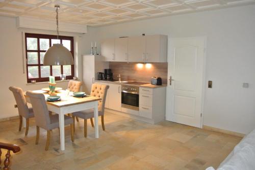 a kitchen and dining room with a table and chairs at Haus Kranenborgh im Mühlenspiegel Steinhude am Meer in Steinhude
