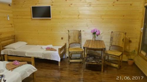 a room with two beds and a table and chairs at Mesto pod Solntsem in Novy Afon