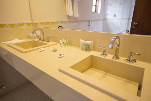 a bathroom with two sinks and a large mirror at Pousada Big Bear in Campos do Jordão