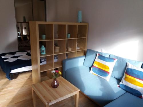 a living room with a blue couch and a table at Muranów Studio in Warsaw