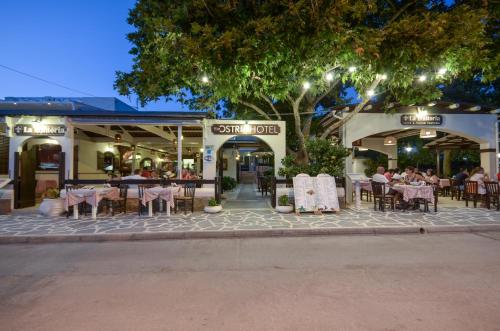 ein Restaurant mit Tischen und Stühlen auf einem Gehweg in der Unterkunft Ostria Hotel in Agios Prokopios