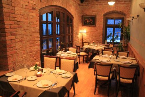 a dining room with tables and chairs and a brick wall at Vecgulbenes muiža in Gulbene