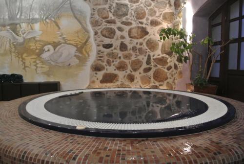 a hot tub in a room with a stone wall at Vecgulbenes muiža in Gulbene