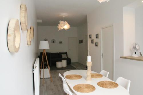 une salle à manger blanche avec une table et des chaises blanches dans l'établissement A & V Appart'hôtel, à Lille