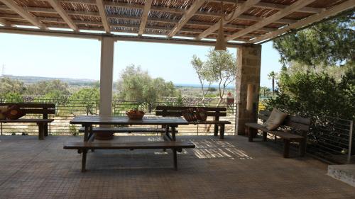 サンニコーラにあるVilla delle Agavi Gallipoliのパティオ(テーブル、デッキ上のベンチ付)