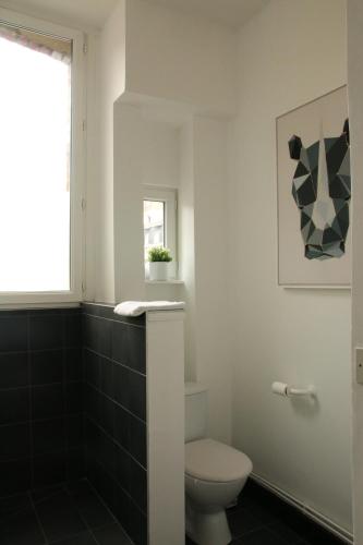 une salle de bain avec toilettes et fenêtre dans l'établissement A & V Appart'hôtel, à Lille