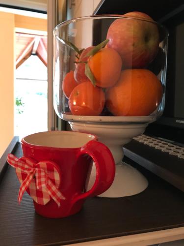 a cup and a bowl of fruit on a desk at Corali in Menídion