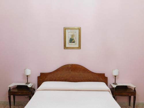 sypialnia z białym łóżkiem i 2 szafkami nocnymi w obiekcie Appartamento Belvedere w Trapani