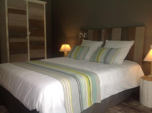 a bedroom with a large bed with white sheets and pillows at Les Rives du Bassin in Le Teich