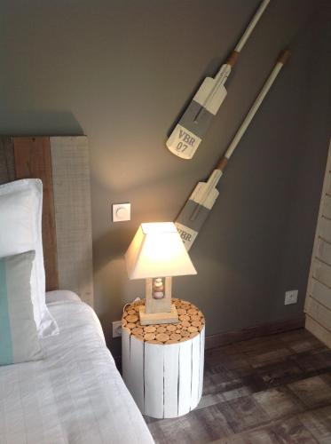 a lamp on a table in a bedroom with two beds at Les Rives du Bassin in Le Teich