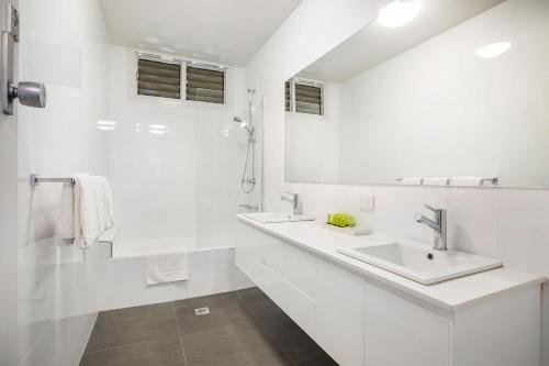a white bathroom with two sinks and a mirror at Nightcap at Waltzing Matilda Hotel in Springvale