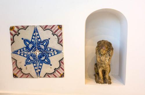 a statue and a painting on a wall next to a sculpture at Villa Pietra Santa in Positano