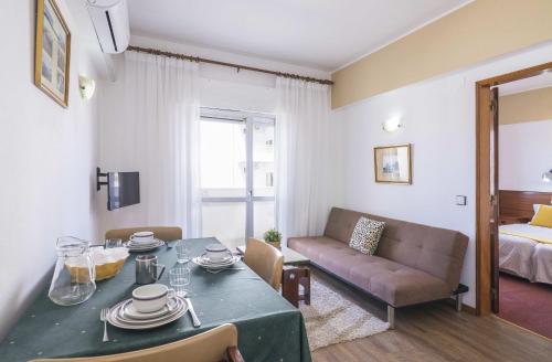 a living room with a table and a couch at Rosamar Apartamentos in Armação de Pêra