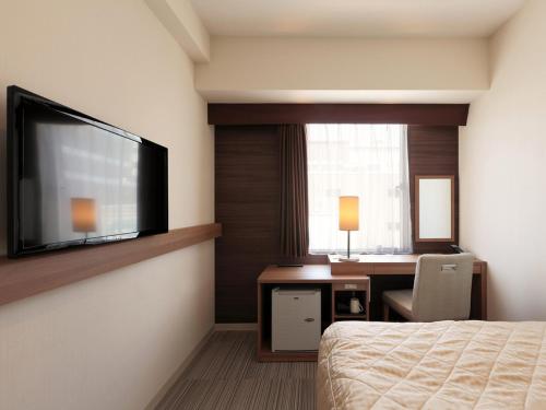 Un pat sau paturi într-o cameră la UNIZO INN Kobe Sannomiya