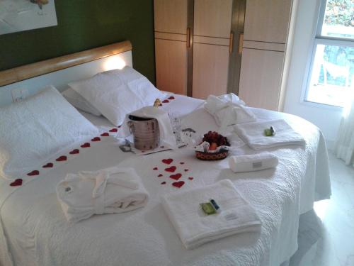 a white bed with towels and a basket of hearts at Apart Quartier Latin Hotel in Vitória