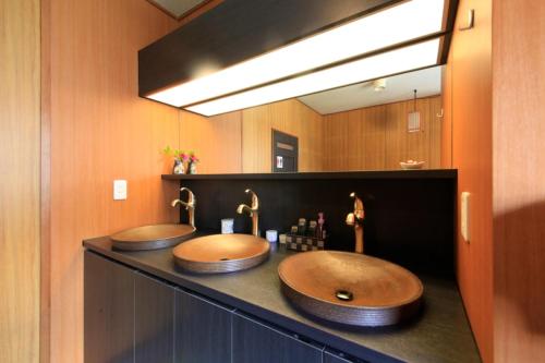 2 umywalki w łazience z dużym lustrem w obiekcie Minshuku Fukufuji w mieście Nikko