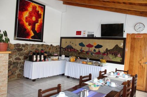 a restaurant with two tables and a counter with wine bottles at Hotel Tierra Inka Sacred Valley in Ollantaytambo