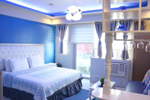 um quarto azul com uma cama e uma janela em Sarasota Residential Resort Manila em Manila