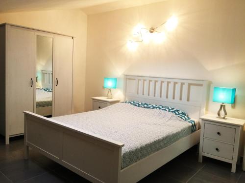 a bedroom with a bed and two lamps on two night stands at Playa Bella in Pérols