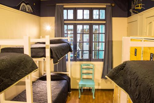 a room with three bunk beds and a window at Hostal Forestal in Santiago