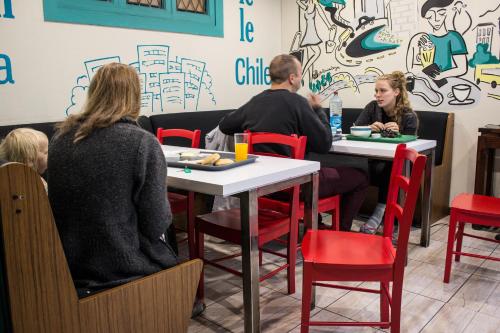 a group of people sitting at tables in a restaurant at Hostal Forestal in Santiago