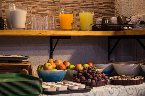 a table topped with bowls of fruit and orange juice at Hostal Forestal in Santiago