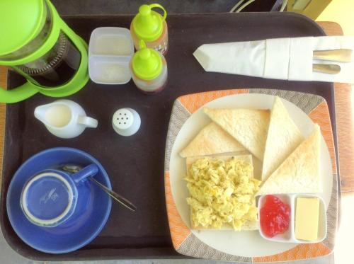 a tray of food with a plate of eggs and bread at Blue Coco in Keramas