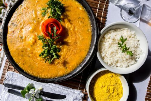 a bowl of curry and rice on a table at Pousada Natureza in Morro de São Paulo
