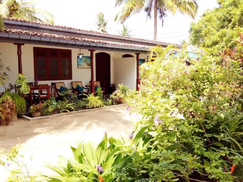 une maison avec un jardin en face dans l'établissement Walauwa The Villa Ahungalla, à Ahungalla