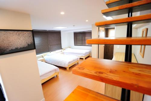 Mały pokój z 2 łóżkami i biurkiem w obiekcie Hannah Guesthouse w mieście Czedżu