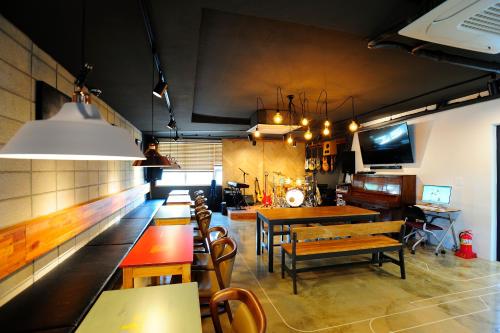 un comedor con mesas y bancos en un restaurante en Hannah Guesthouse en Jeju