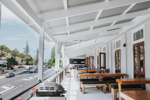 an outdoor patio with tables and benches and a street at Coolangatta Sands Hotel in Gold Coast
