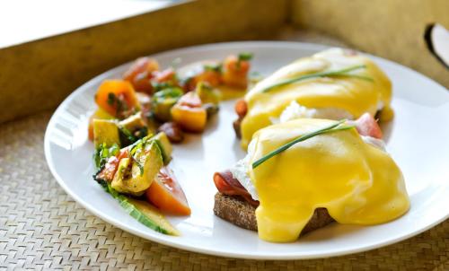 een witte plaat met een ei sandwich en groenten bij Planta Boutique Resort in Canggu