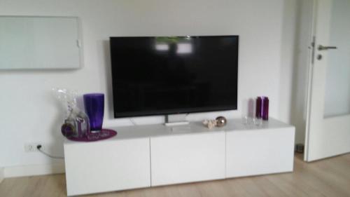 a white entertainment center with a flat screen tv on it at Ferienwohnung Christa in Bad Staffelstein