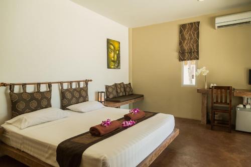 a bedroom with a large bed with purple flowers on it at Angkana Bungalows adults only in Thongsala