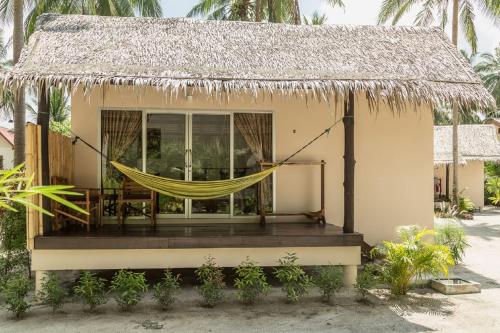 a house with a hammock in front of it at Angkana Bungalows adults only in Thongsala