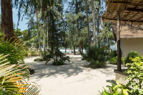 a pathway with trees and a beach in the background at Angkana Bungalows adults only in Thongsala