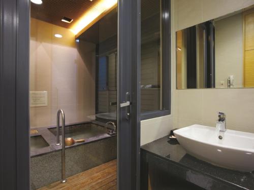 a bathroom with a sink and a mirror at The Sun Hot Spring & Resort in Taichung