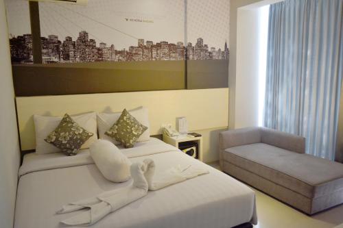 um quarto de hotel com uma cama e uma cadeira em Vio Cihampelas em Bandung