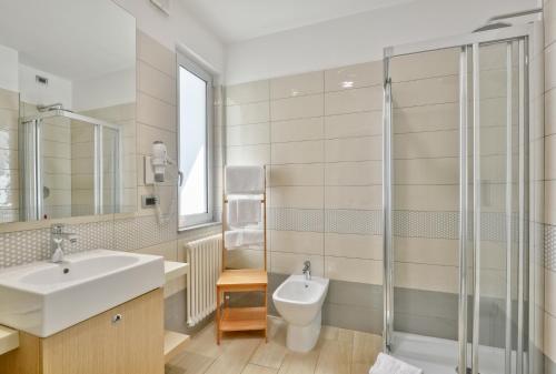 y baño con lavabo, aseo y ducha. en Hotel Serenella, en Agropoli