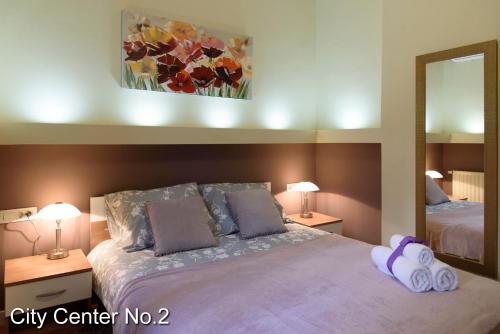 een slaapkamer met een bed met 2 kussens en een spiegel bij Apartments City Center in Zagreb