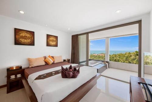 a bedroom with a large bed and a large window at Tranquil Residence 2 - Luxury Apartment in Lamai