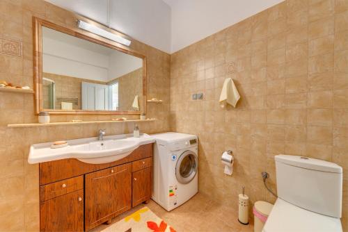 y baño con lavadora y lavamanos. en Syros Private House with superb sea view, en Kini