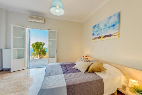 a bedroom with a bed and a view of the ocean at Syros Private House with superb sea view in Kinion