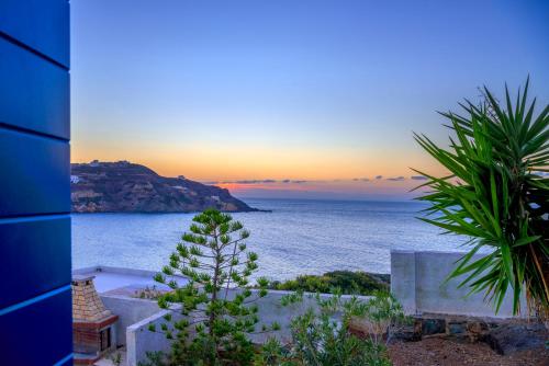 a view of the ocean at sunset from a building at Syros Private House with superb sea view in Kinion